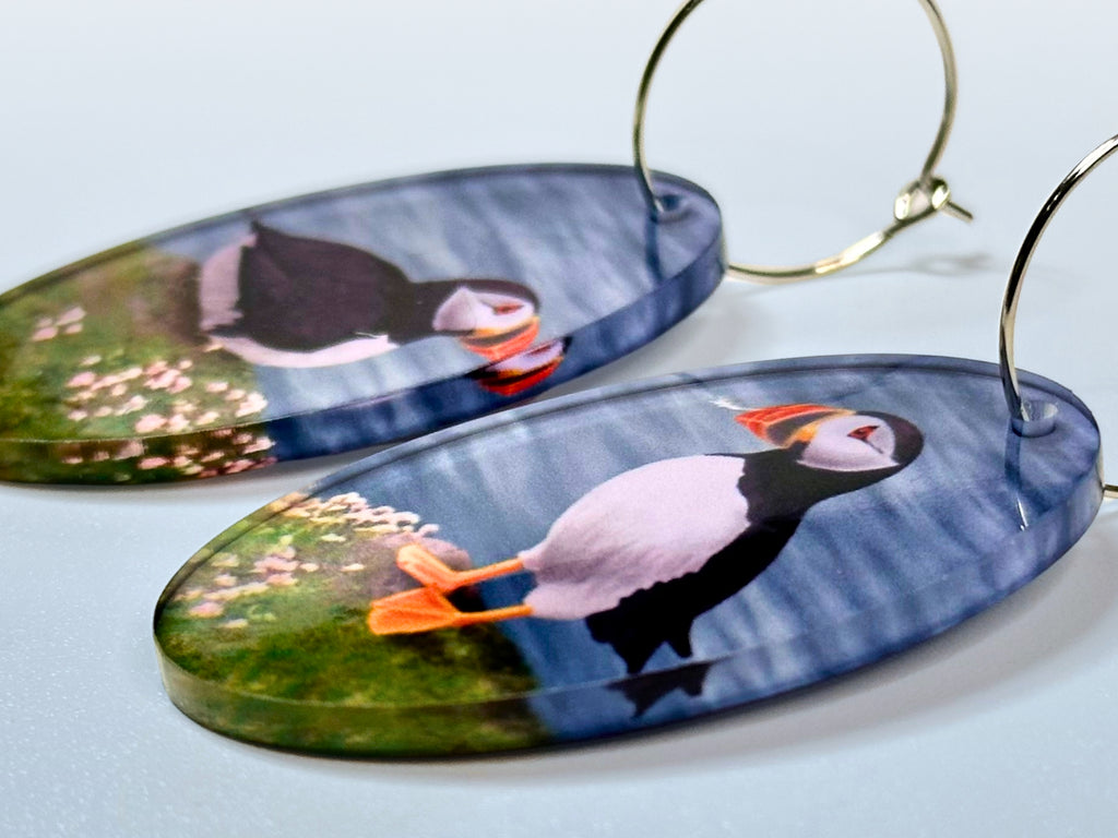 Side view of puffin acrylic earrings showing glossy artwork and thickness