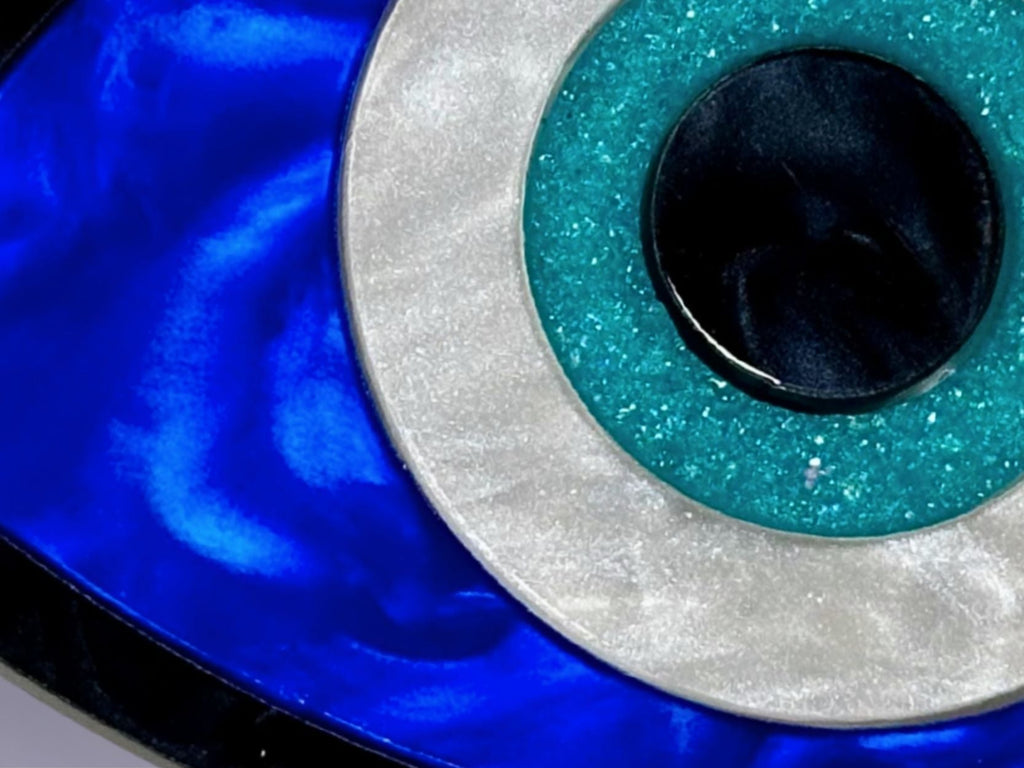 close up of evil eye jewelry set showing layered acrylic detail iridescent and textured finishes