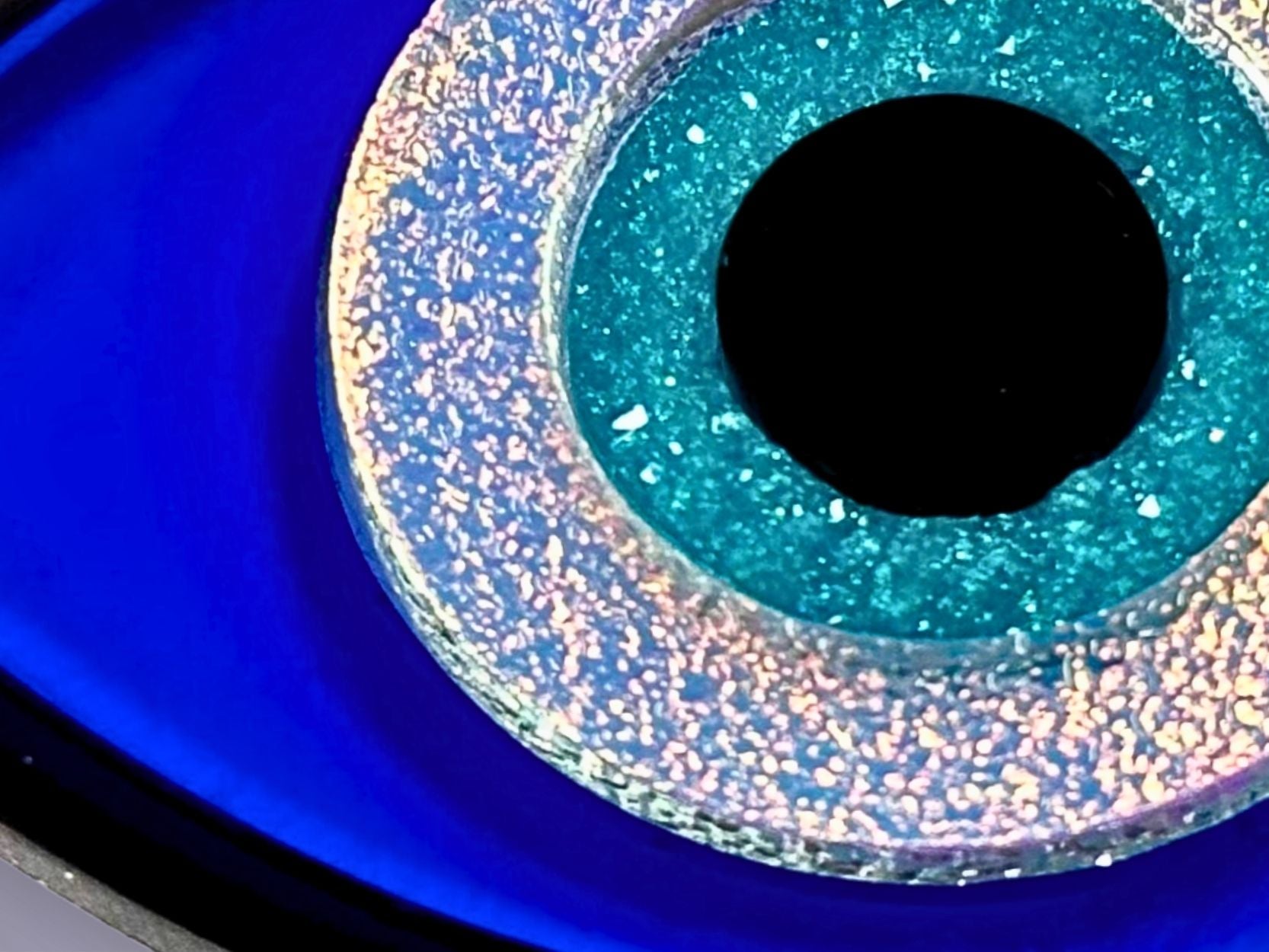 close up of evil eye ritual set showing layered acrylic detail resin druzy crystal iridescent and textured finishes blue white black