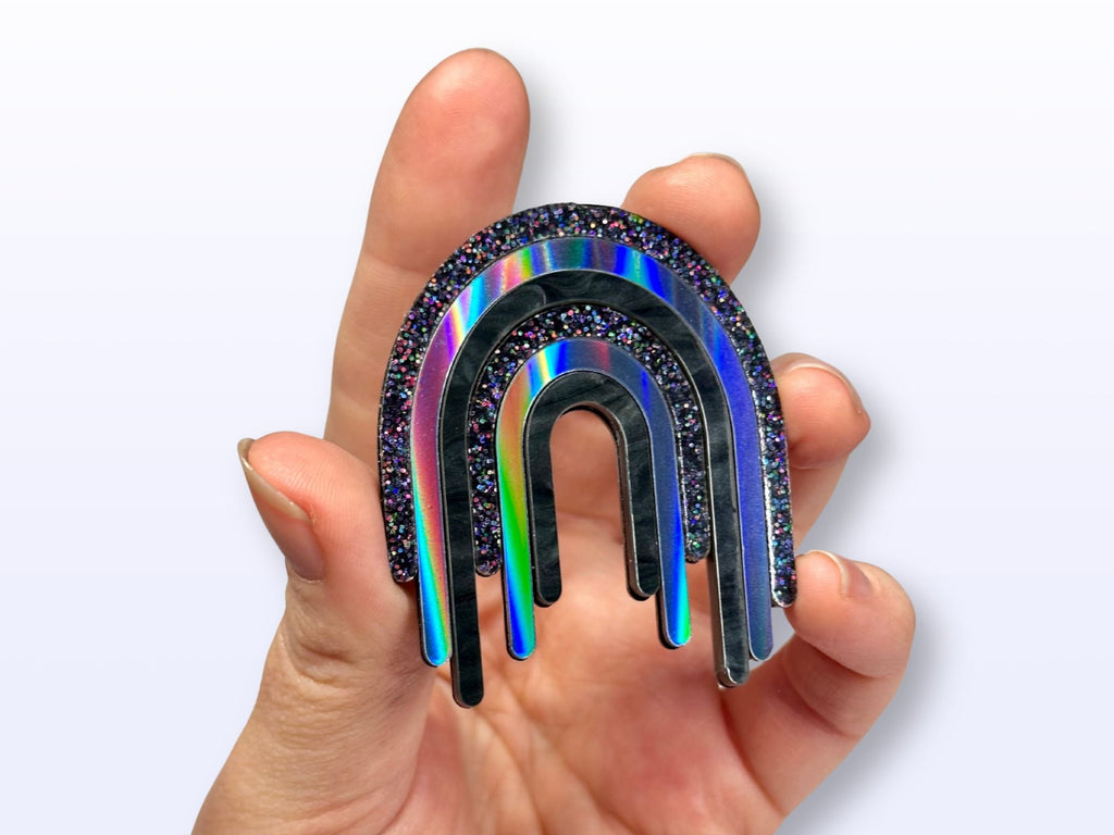 Hand holding Full Spectrum Rebel Drip Brooch for scale