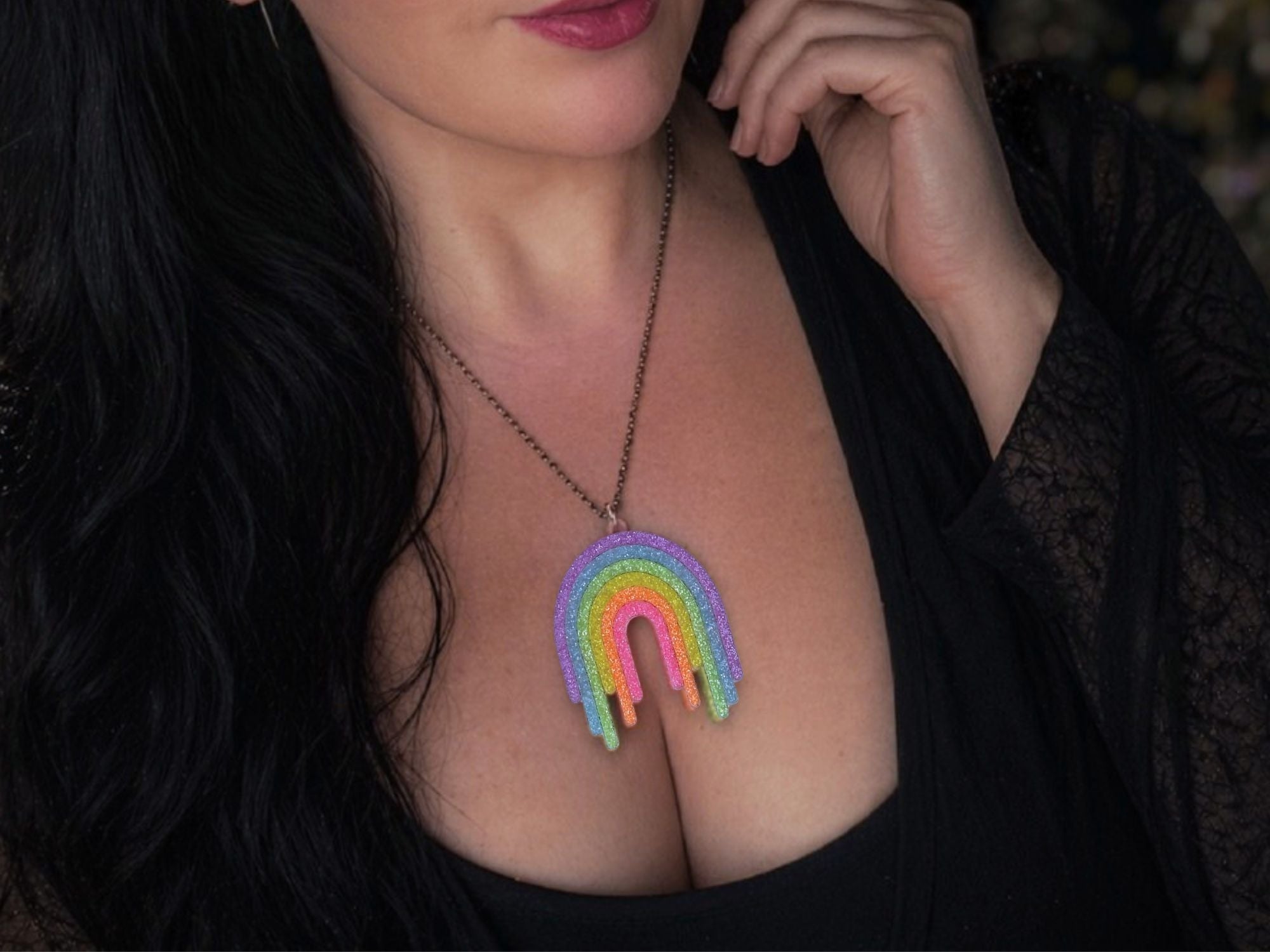 Model wearing Full Spectrum Rebel Rainbow Rave drip pendant necklace in glitter acrylic.