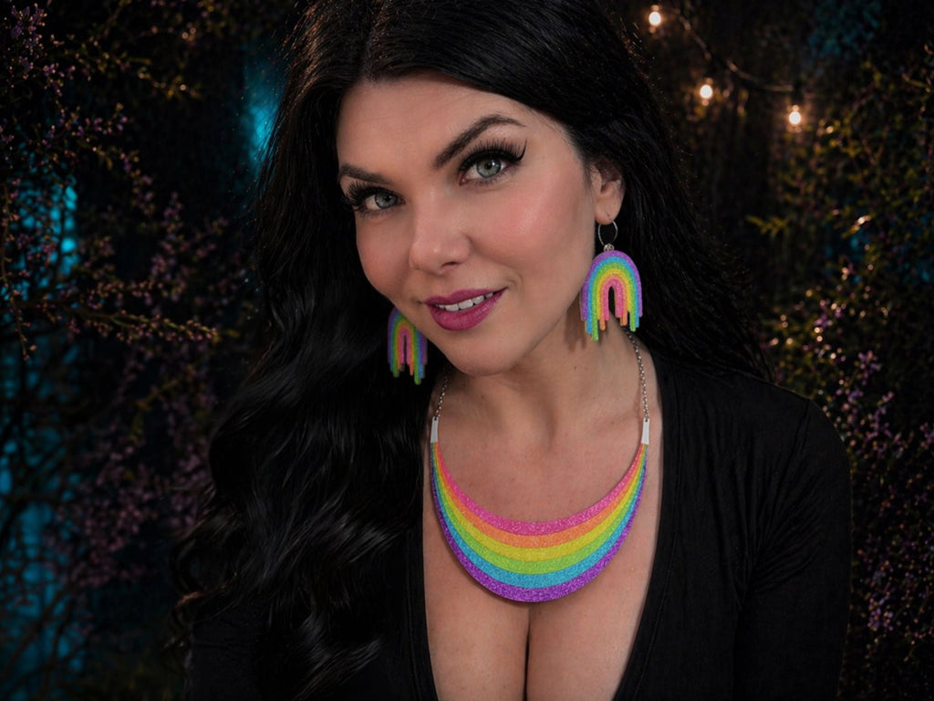Model wearing Full Spectrum Rebel Rainbow Rave statement necklace and rainbow drip earrings.