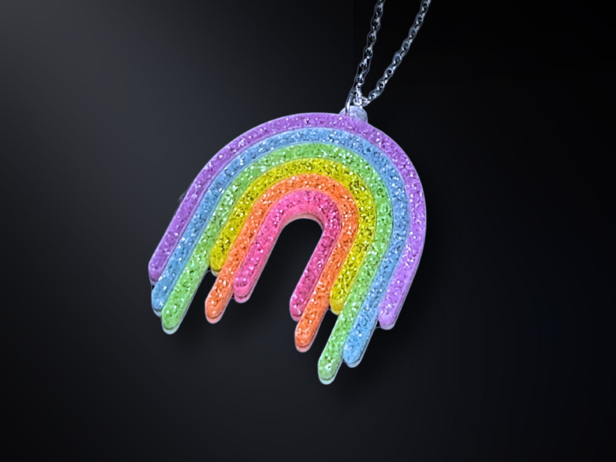 Full Spectrum Rebel Rainbow Rave drip pendant necklace in glitter acrylic on dark gradient background.