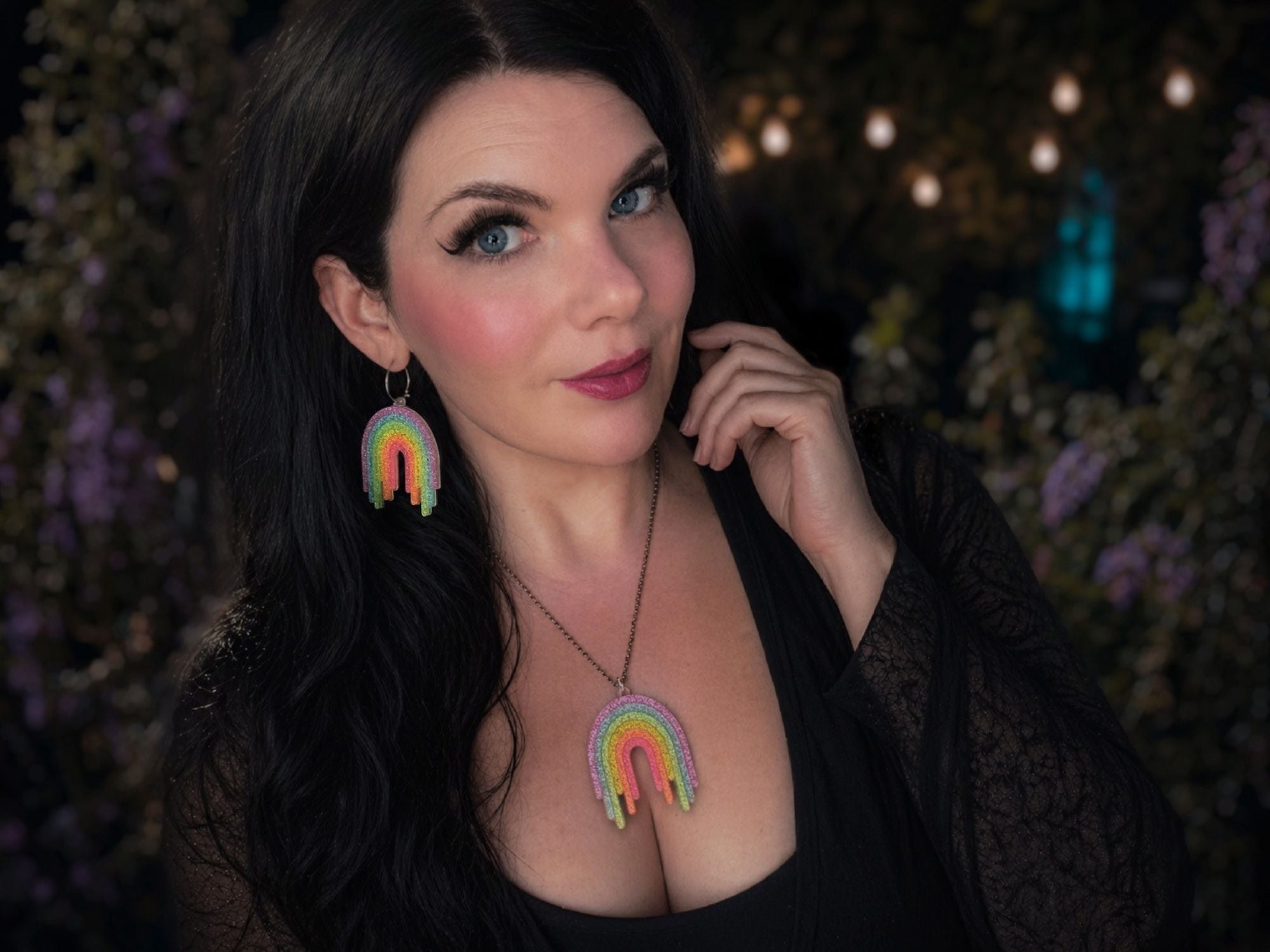 Model wearing Full Spectrum Rebel Rainbow Rave drip pendant necklace and matching rainbow earrings.