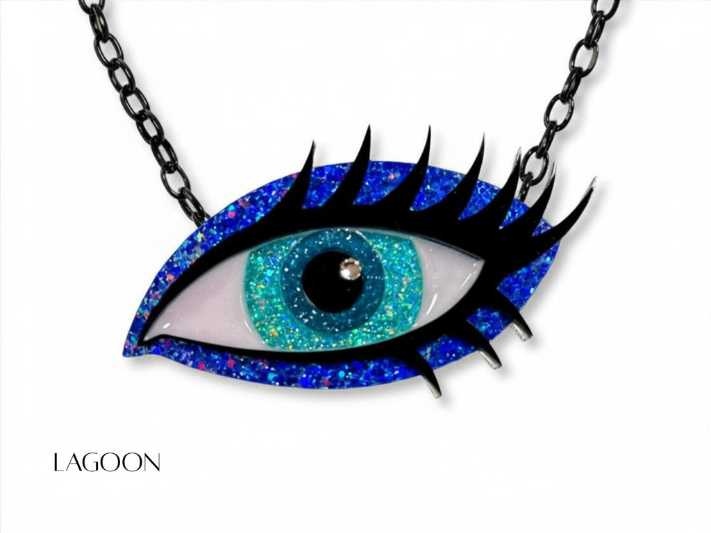 Lagoon Siren Eye necklace with turquoise glitter iris, vivid blue glitter acrylic, dramatic black lashes, and black chain.