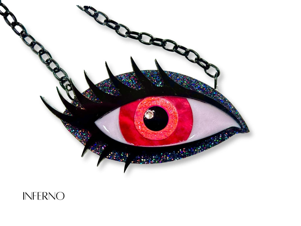 Inferno Siren Eye necklace with vivid red and orange iris, black holographic glitter acrylic, black lashes, and black chain.