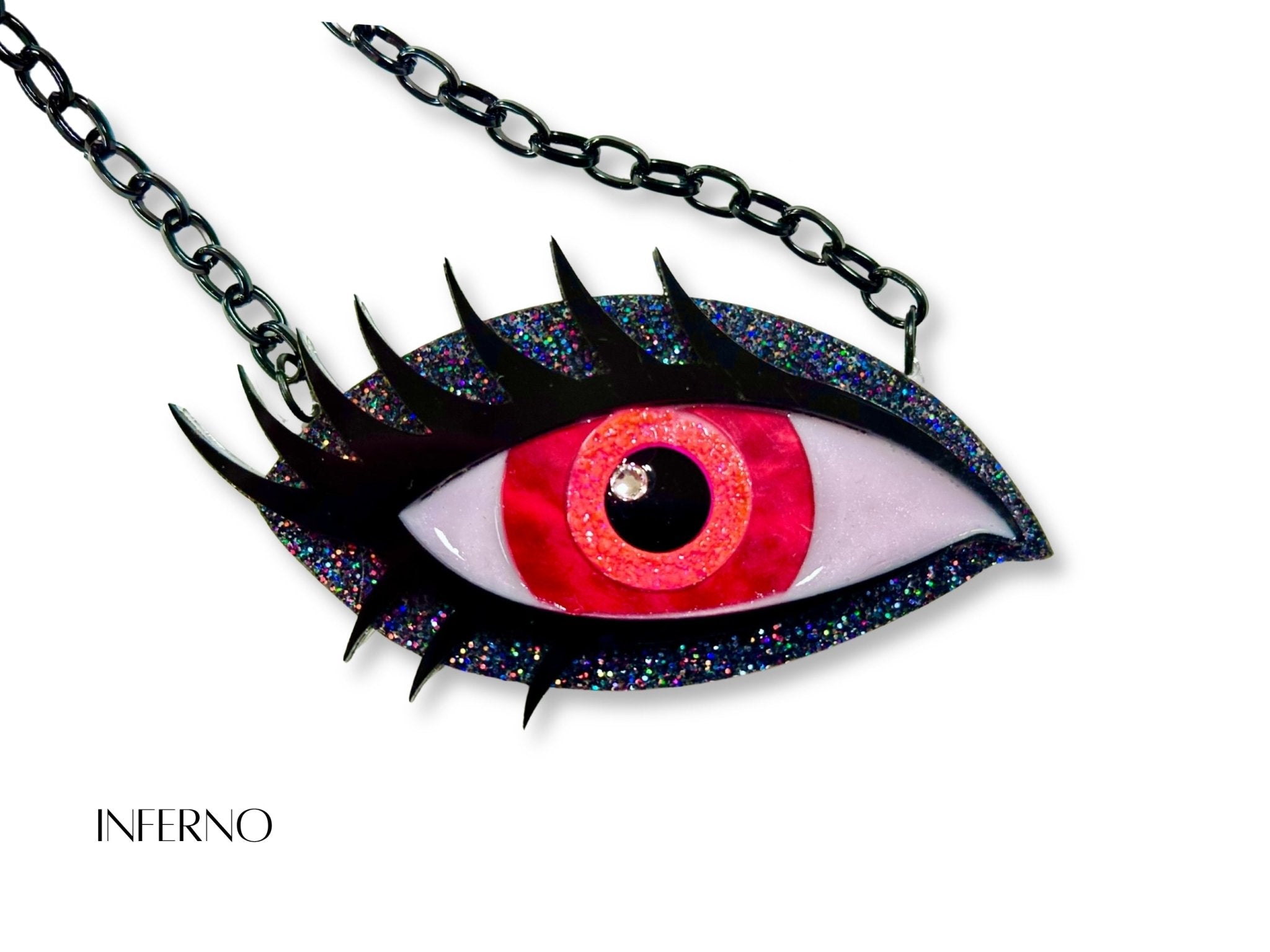 Inferno Siren Eye necklace with vivid red and orange iris, black holographic glitter acrylic, black lashes, and black chain.