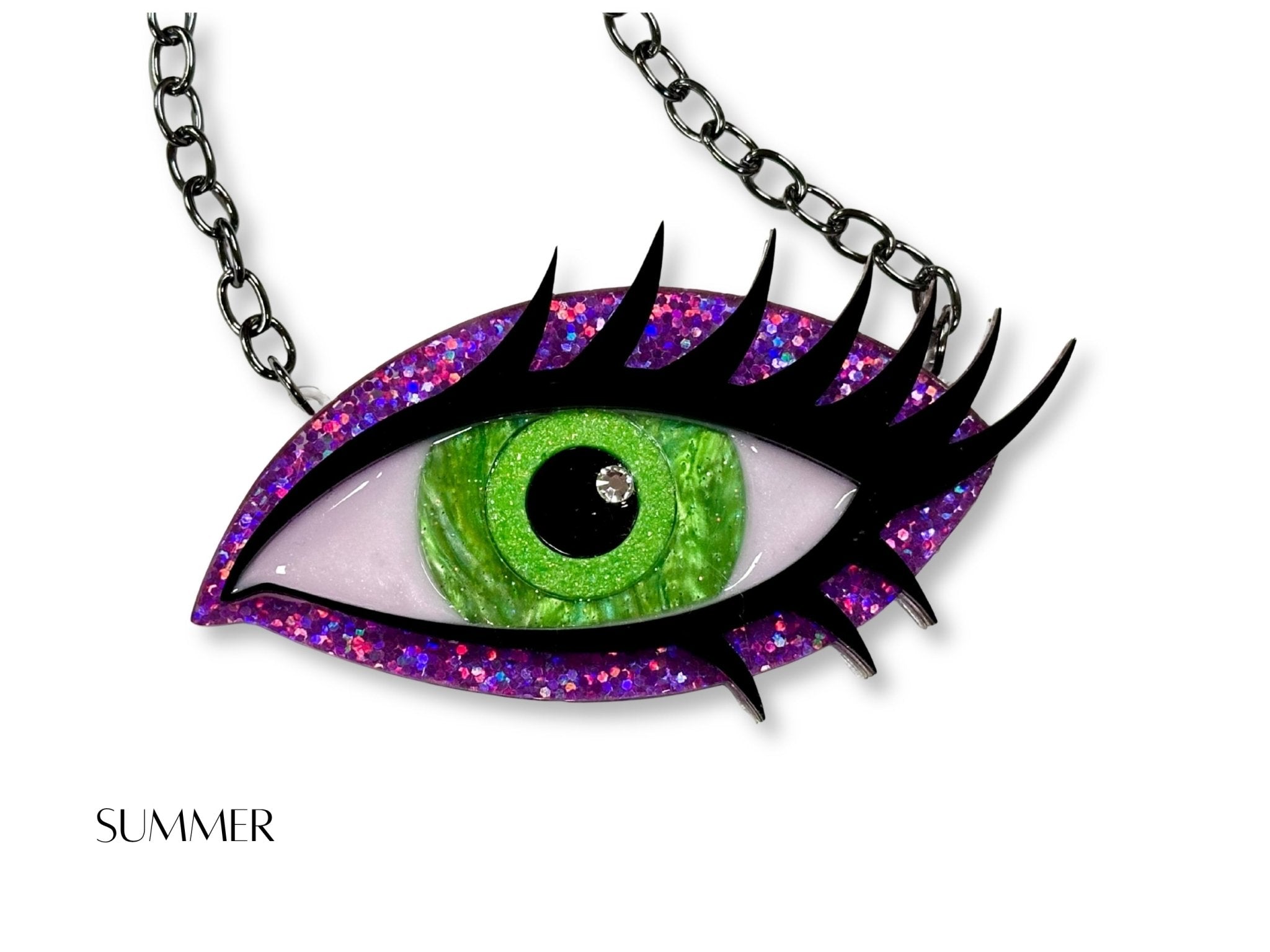 Summer Siren Eye necklace with bright green iris, purple and pink glitter acrylic, dramatic black lashes, and black chain.